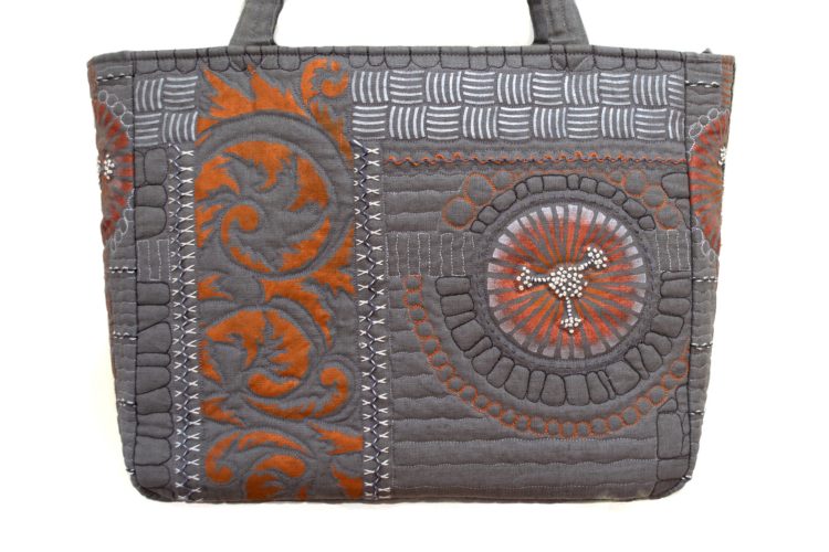 April Sproule, Gray and Rust Art Tech Satchel, 2015. 38cm x 30cm x 8cm (15” x 12” x 4”). Stencilling, hand embroidery, free-motion quilting. Linen, textile paints, cotton floss, original stencils.