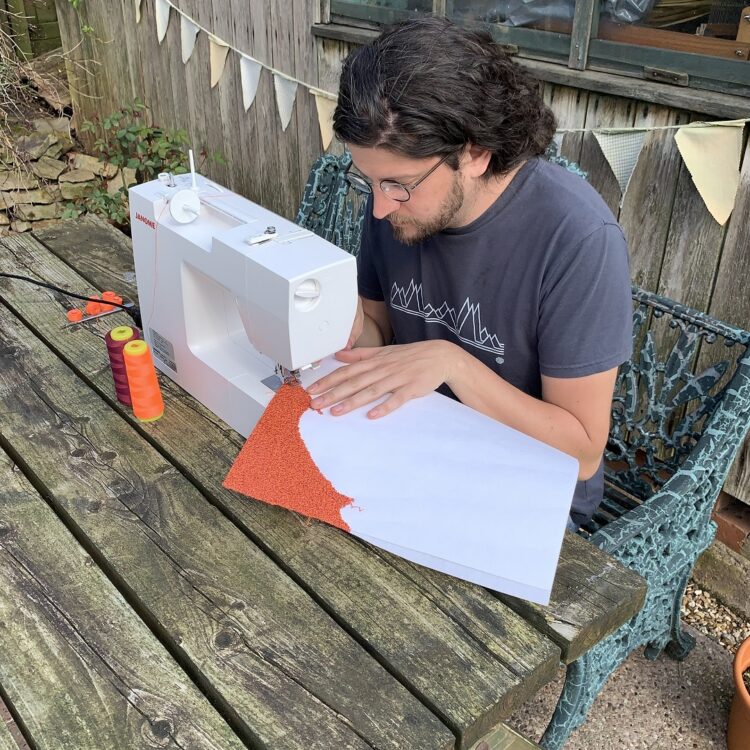 Dr. Jack Roberts sewing outside.